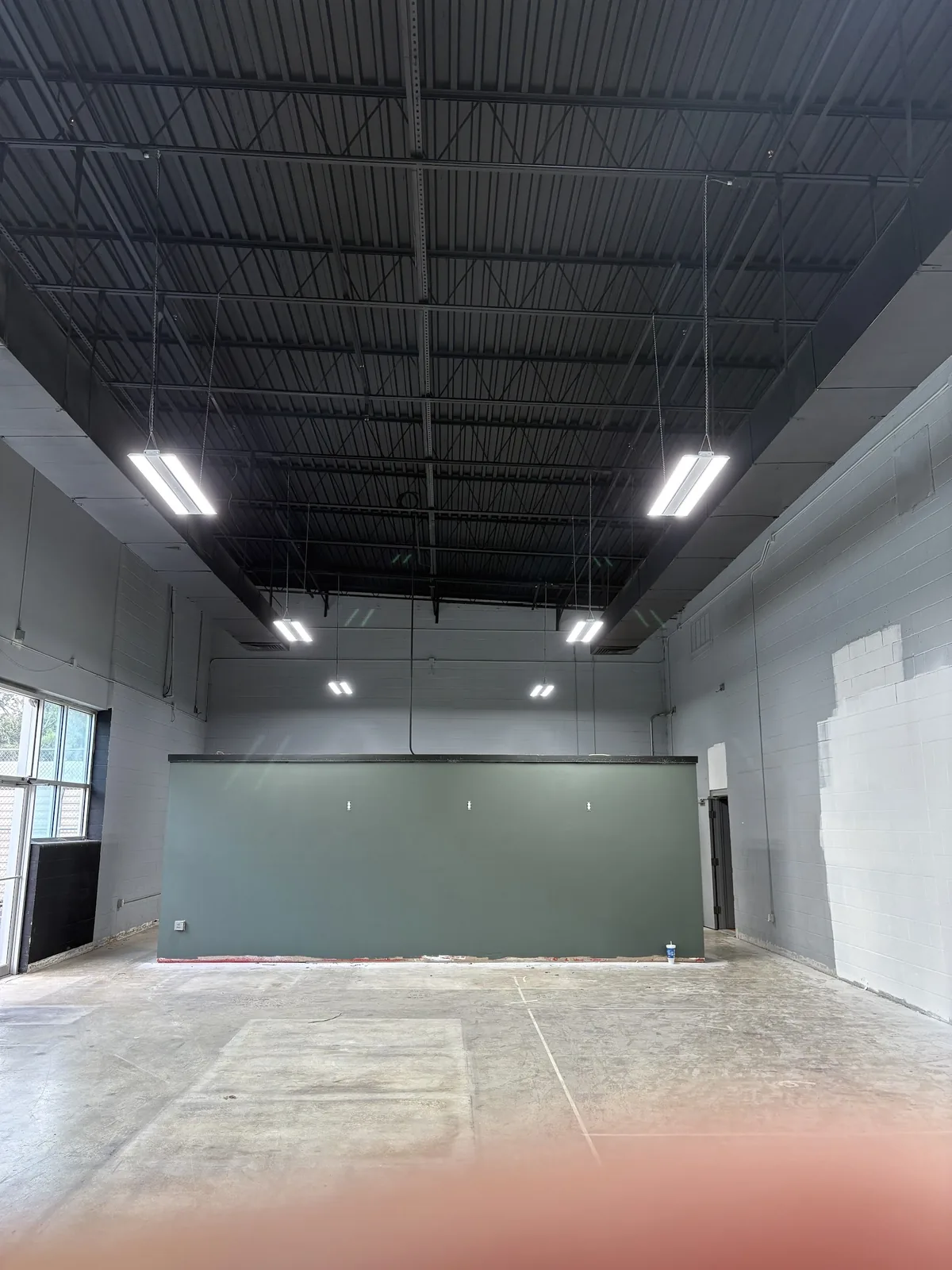 Finished commercial room illuminated by ceiling fixtures