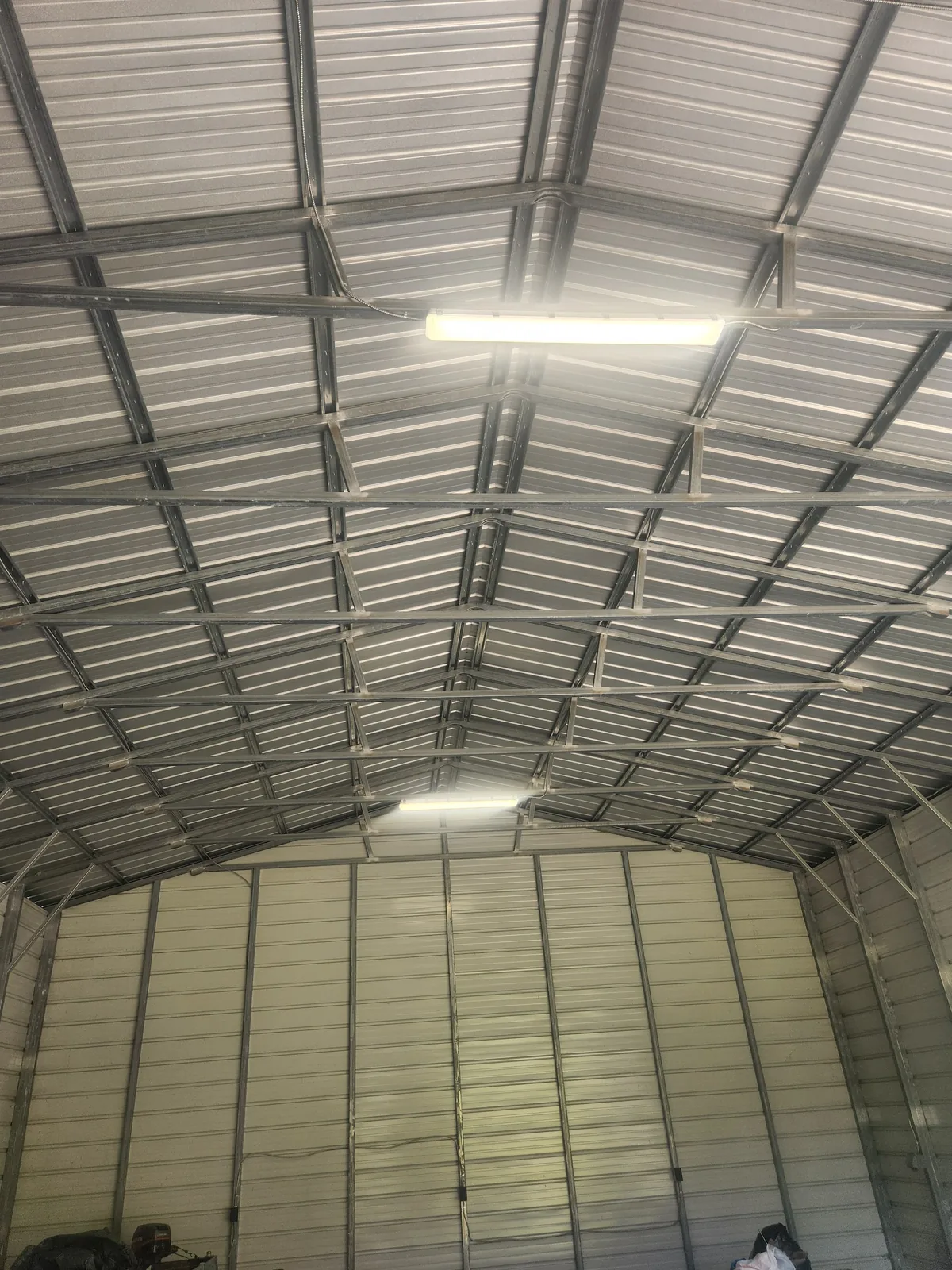 Parallel conduit runs across a metal building ceiling