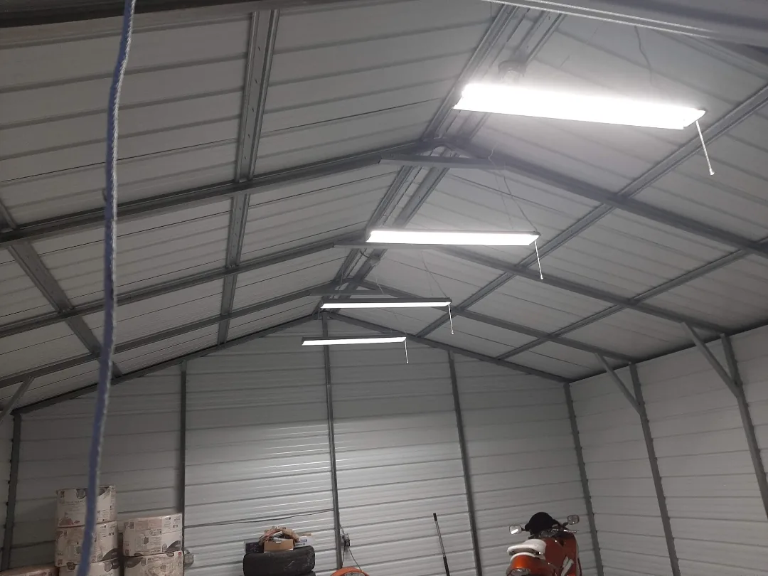 Rows of bright LED fixtures in a high metal-building ceiling