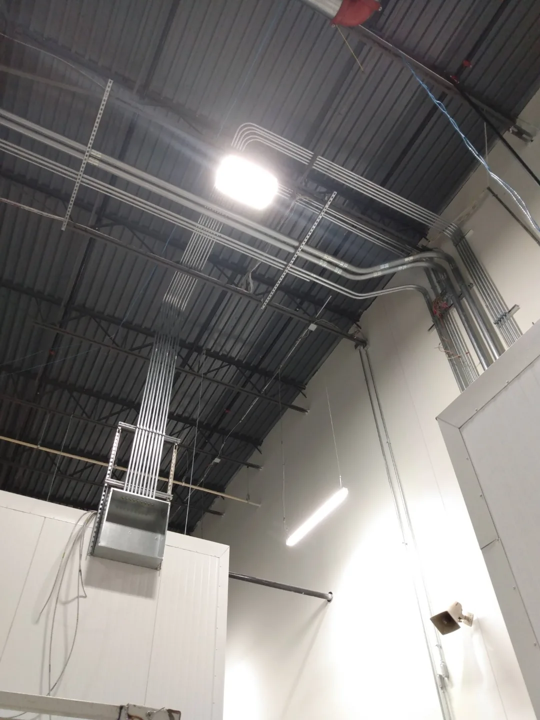 Overhead conduit and cable trays in a high-ceiling commercial space