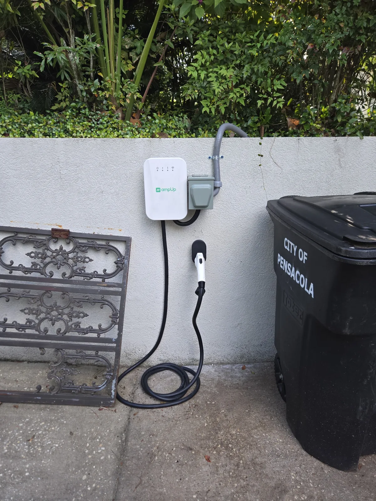 Wall-mounted electric vehicle charger beside a parking area