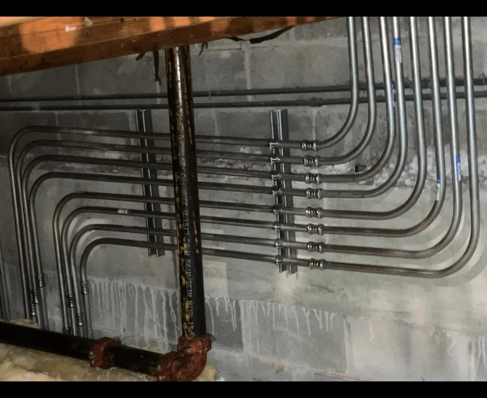 Parallel metal conduit runs installed along a commercial wall
