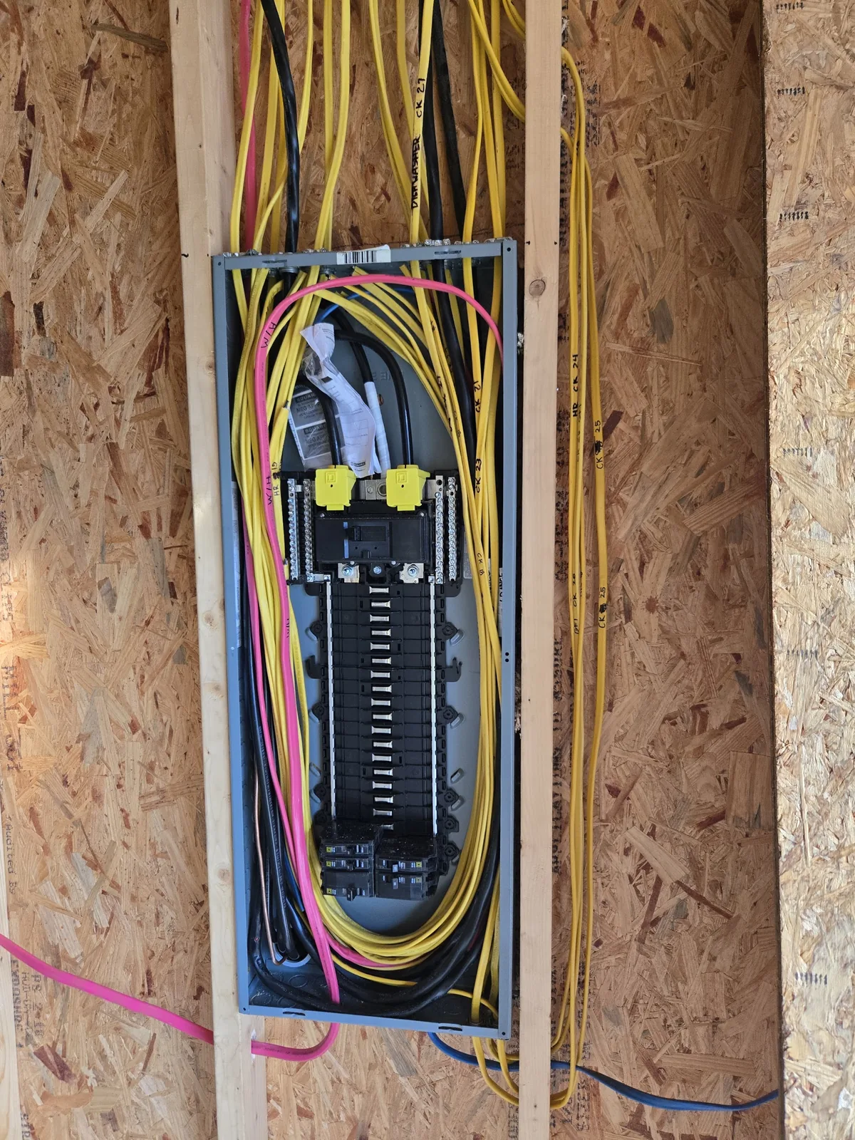 Breaker panel and branch wiring installed in exposed wood framing