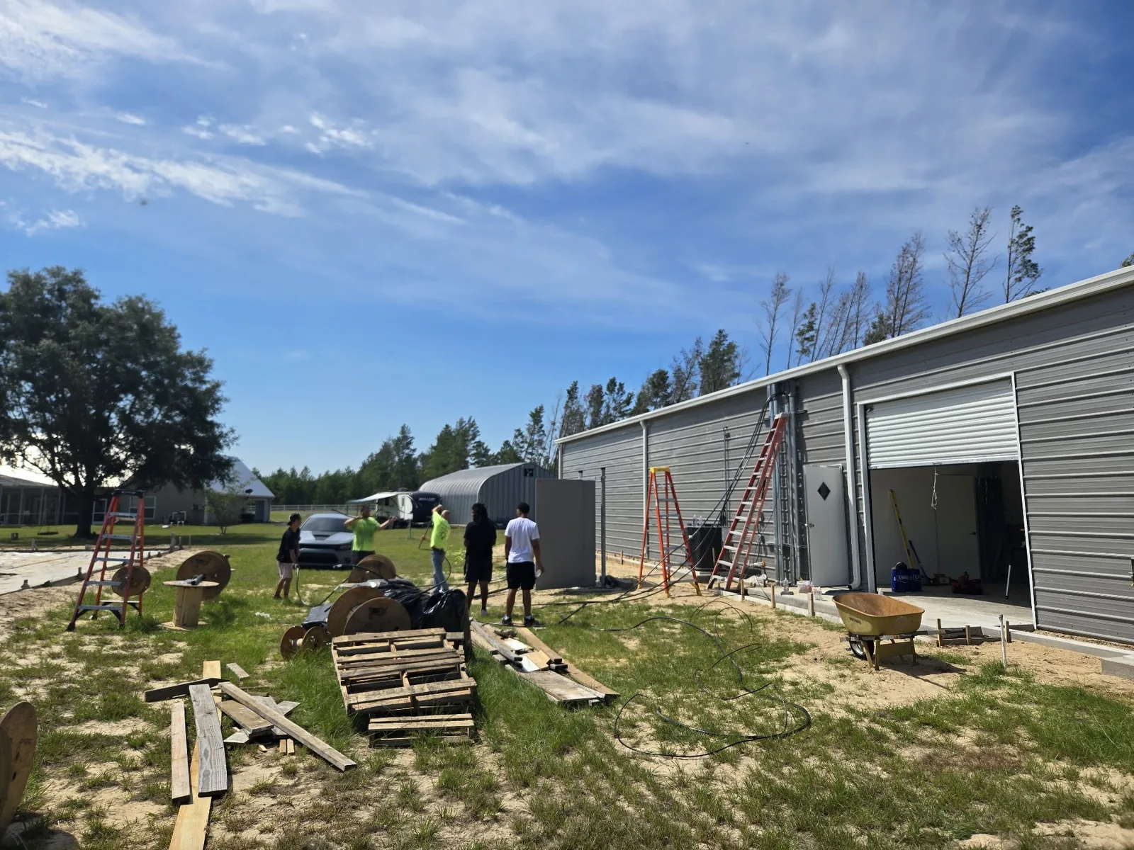 Electricians working along the exterior of a commercial building