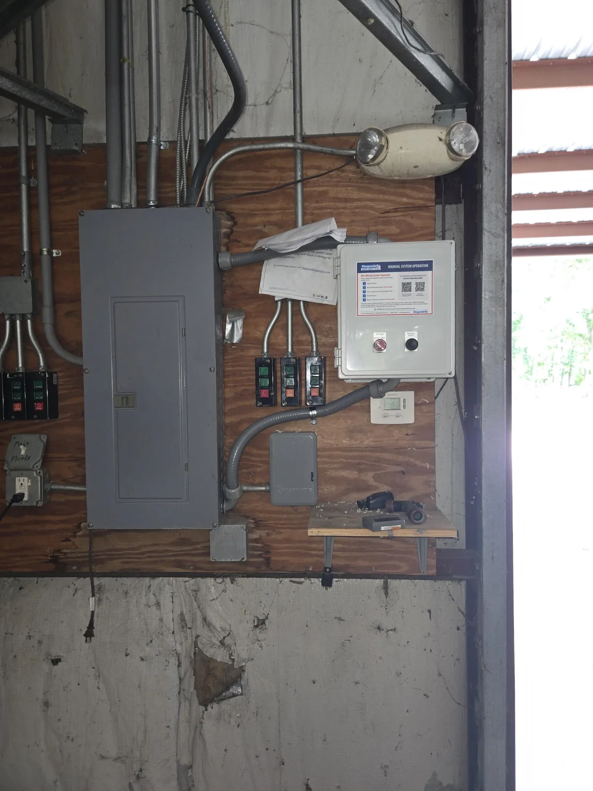 Commercial electrical panels and controls mounted on a plywood service wall